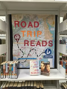 a book shelf with books on it and a sign reading road trip reads in the background