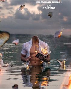 a man standing in the water holding a book with fire coming out of his chest