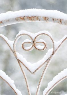 a heart shaped iron gate with snow on it