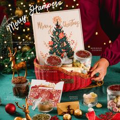 a christmas card and gift basket on a table surrounded by other holiday treats, candies, and decorations