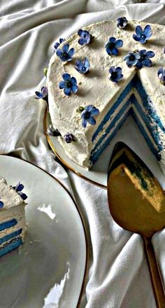 a piece of cake with blue flowers on it is next to a knife and fork