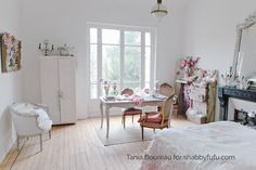 a bedroom with white walls and wooden floors has a bed, desk, chair, dresser and mirror in it