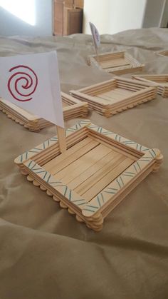 four wooden frames sitting on top of a bed next to a white sailboat sign