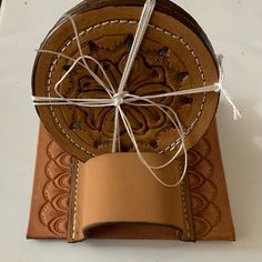 a brown leather coaster tied up with twine