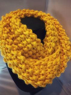 a yellow knitted scarf on a black mannequin