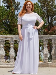 a woman in a long white dress posing for the camera