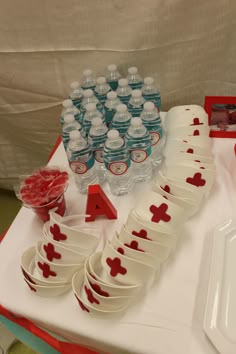 a table topped with plates and cups filled with water bottles next to a sign that says i love you