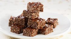 a white plate topped with brownies covered in chocolate