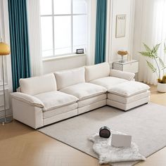 a living room with a white sectional couch and blue drapes on the windowsill