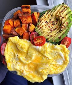 an egg omelet with tomatoes, avocado and other vegetables in a plastic container