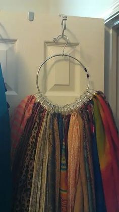 an assortment of scarves hanging from a hook