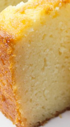 a piece of yellow cake sitting on top of a white plate next to a fork