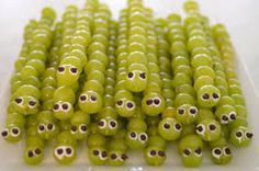 green peas with googly eyes are arranged on a white plate, ready to be eaten