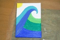 a piece of paper that has been made to look like a blue and green wave