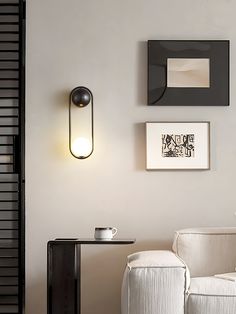 a living room with two white chairs and a black table in front of the wall