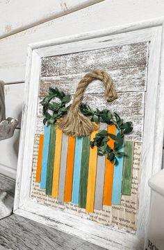 an old picture frame is decorated with colorful strips and a basket as the centerpiece