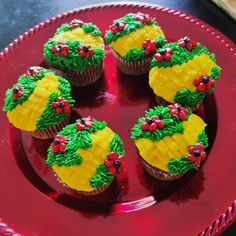 cupcakes decorated with green and yellow frosting on a red plate in the shape of pineapples