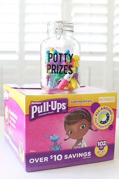 a bottle filled with lots of toys sitting on top of a box that says potty prizes