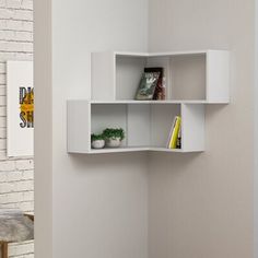 a white shelf with some books on top of it next to a brick wall in a room