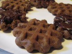 chocolate waffles are arranged on a white plate