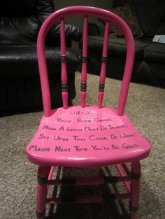 a pink wooden chair with writing on it