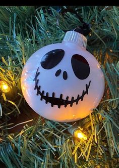 a white ornament with black eyes and a jack skellingy face on it