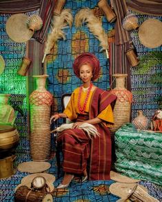 a woman sitting on top of a chair in front of vases and other items