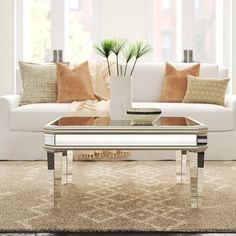 a living room with a couch, coffee table and pillows on the carpeted floor