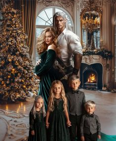 a man and woman standing next to two children in front of a christmas tree