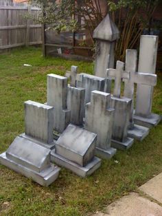 a group of cement tombstones sitting in the grass