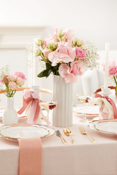 the table is set with pink and white flowers