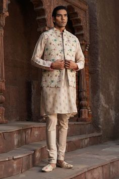 Ivory base kurta with mughal floral prints. Paired with a churidar. Comes along with a bundi with mughal prints. - Aza Fashions Beige Nehru Jacket For Festive Transitional Season, Traditional Beige Nehru Jacket For Transitional Season, Festive Beige Nehru Jacket With Naqshi Detailing, Festive Beige Nehru Jacket With Naqshi, Transitional Designer Cream Nehru Jacket, Designer Nehru Jacket With Dabka In Beige, Designer Dabka Nehru Jacket In Beige, Cream Nehru Jacket With Naqshi For Festivals, Designer Festival Nehru Jacket In Cream