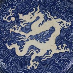 a blue and white plate with a dragon on it