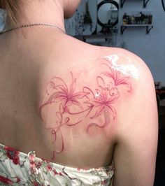 a woman's back with pink flowers on her upper arm and shoulder tattoo design