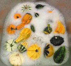 there are many different fruits and vegetables in the bathtub with soapy water on it