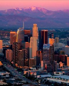 an aerial view of a city with mountains in the background