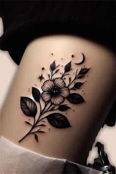 a woman's thigh with flowers and stars on the side, in black ink