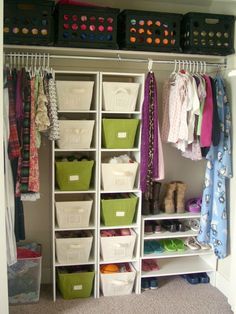 an organized closet with white shelves and green bins