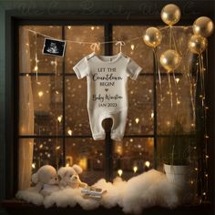 a baby's first birthday outfit hanging in front of a window