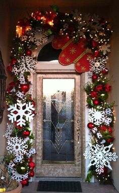 the front door is decorated for christmas with snowflakes and wreaths on it