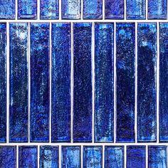 blue glass tiles are arranged in rows on the wall