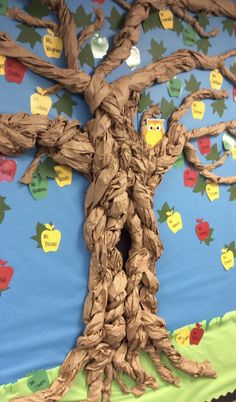 a bulletin board with a tree made out of paper and some writing on the wall