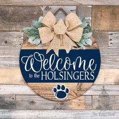 welcome to the holsingers door hanger with a bow and paw print