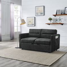 a living room scene with focus on the couch and rugs in front of the window