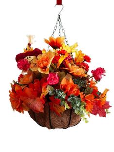 a hanging basket filled with lots of different colored flowers and leaves on a white background