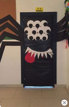 a door decorated with black paper and some decorations on the wall behind it is an image of a monster's mouth