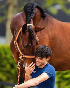 a man is petting a brown horse