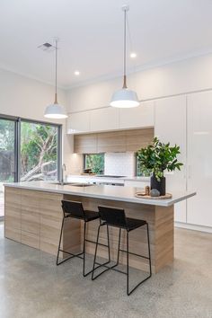 a kitchen with an island and two bar stools