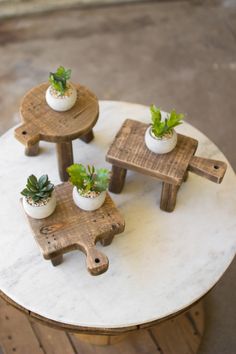 three small wooden stools with plants in them