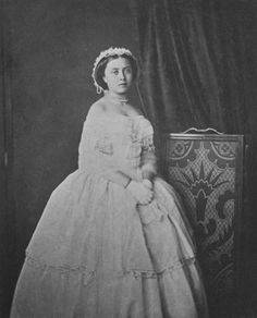 an old black and white photo of a woman in a dress